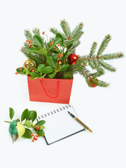Shopping bag with Christmas decorations and notebook isolated