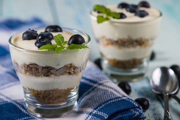 Glass with muesli creamy yogurt and fresh blueberries
