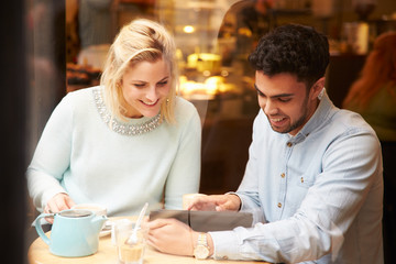 Couple Viewed Through Window Of Caf‚ Using Digital Tablet
