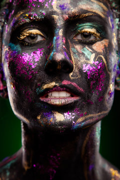 brunette with glowing disco makeup. Black face and neon face art