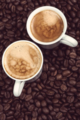 Fresh creamy expresso over roasted coffee beans background