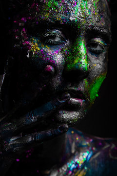 Girl with neon flicker on the face. Black face art.