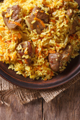 Rice with meat and vegetables macro. vertical top view