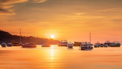 Fototapeta na wymiar sunrise with colorful sky and boats on the beach
