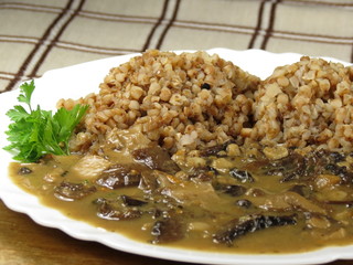 Buckwheat with mushrooms on plate - vegan meal. Closeup.