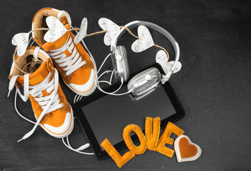 Love for music concept.Orange sneakers, headphones, tablet and h
