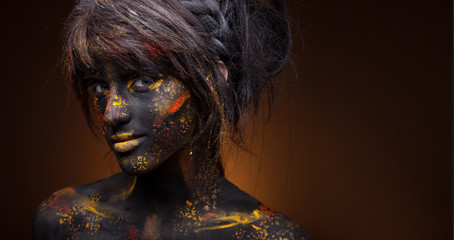 dark portrait of woman in black paint with yellow smudges