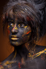 dark portrait of woman in black paint with yellow smudges