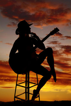silhouette of a woman with a guitar hand under chin