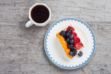 Fruit tart on plate served with coffee