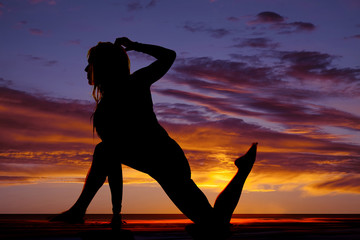 silhouette of woman on one foot and one knee hand down