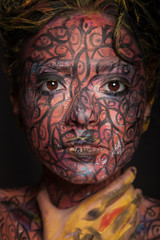 young woman with creative red  face-art and afro hair