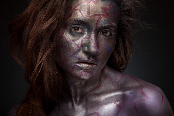 Beautyful girl with silver and violet glitter on her face