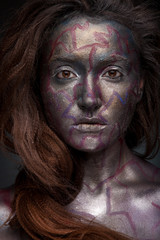 Beautyful girl with silver and violet glitter on her face