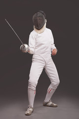 girl in white fencing costume. with sword and  fencing mask 