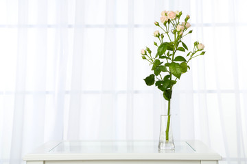 Beautiful bouquet of flowers in vase on window background