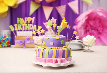 Delicious birthday cake on table on bright background