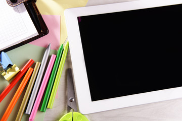 Tablet PC with office supplies on desktop background