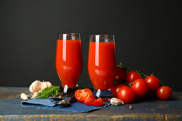 Glasses of tasty tomato juice and fresh tomatoes