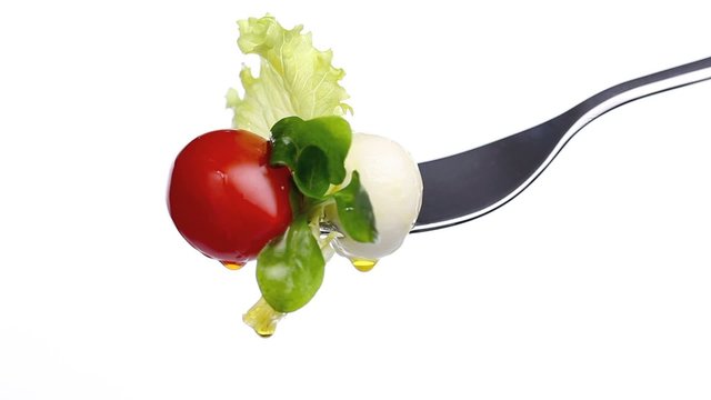 fork lettuce salad leaves, tomato and mozzarella topped with oli