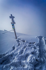 Obraz premium Snowy signpost on a mountain peak