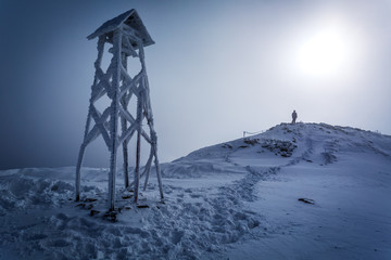 Fototapeta premium Lone man on the top of the mountain in winter