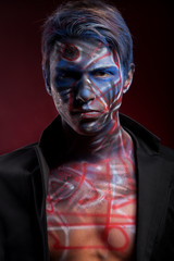 A creepy portrait of a man with bloody body art and face art
