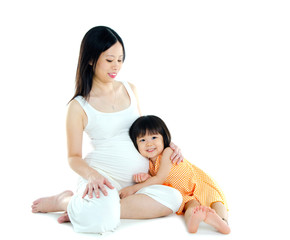 Cute asian girl listening to her pregnant mother's stomach