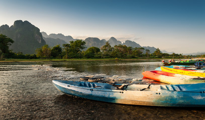kayak and longtail boats in Nam Song river at Vang Vieng, Laos