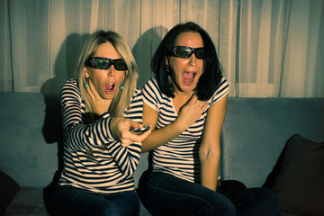 Fototapeta premium Two women watching 3D movie at home