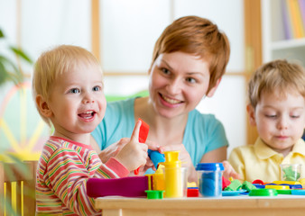 Obraz na płótnie Canvas woman playing and teaching with children