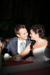 Bride and groom drinking coffee at an indoor cafe