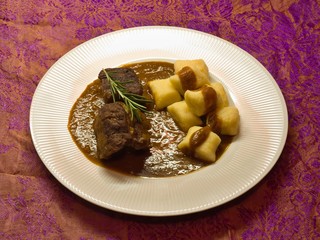 Roasted wild game in ginger bread sauce with potato dumplings
