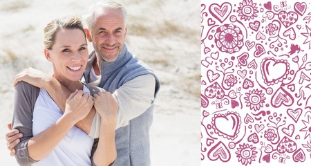 Hugging couple on the beach looking at camera