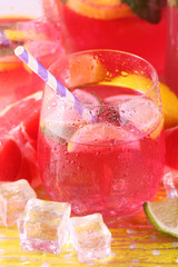 Pink lemonade in glasses and pitcher on bright background