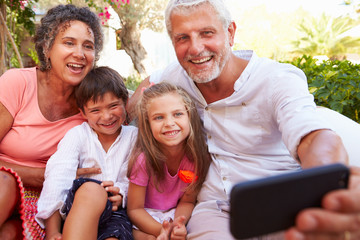 Grandparents With Grandchildren In Garden Taking Selfie