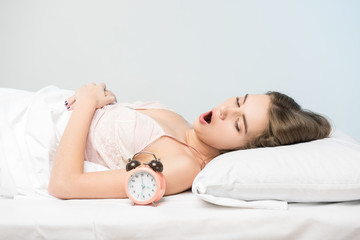 beauty lying on the bed with a clock