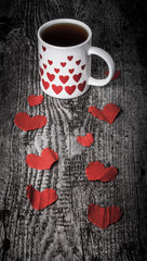 Valentine hearts and cup of tea on the old wooden table. Toned