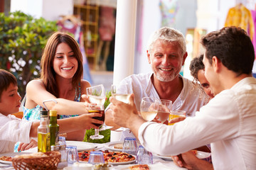 Multi Generation Family Eating Meal At Outdoor Restaurant