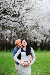 boy and girl on the background of blossoming apricot. A guy hugs