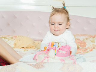 Small caucasian child girl on happy birthday with cake at home
