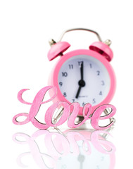 Pink alarm clock and the word 