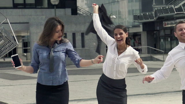 Happy businesspeople dancing in the city,
