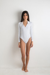 Woman full body portrait against white wall background.