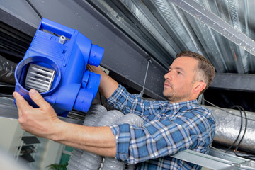 Electrician fitting a ventilation system