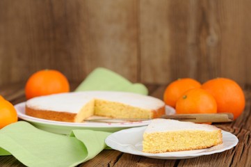 Cut clementine pie with clementines on wooden background
