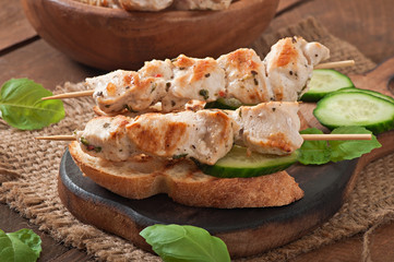 Chicken kebabs on skewers with toast