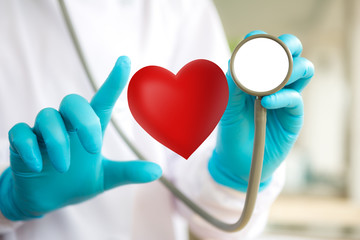 Doctor with stethoscope and red heart  in hand
