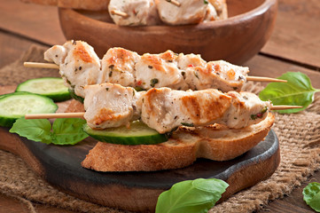 Chicken kebabs on skewers with toast