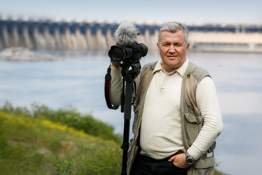 The man's portrait with the camera and tripod
